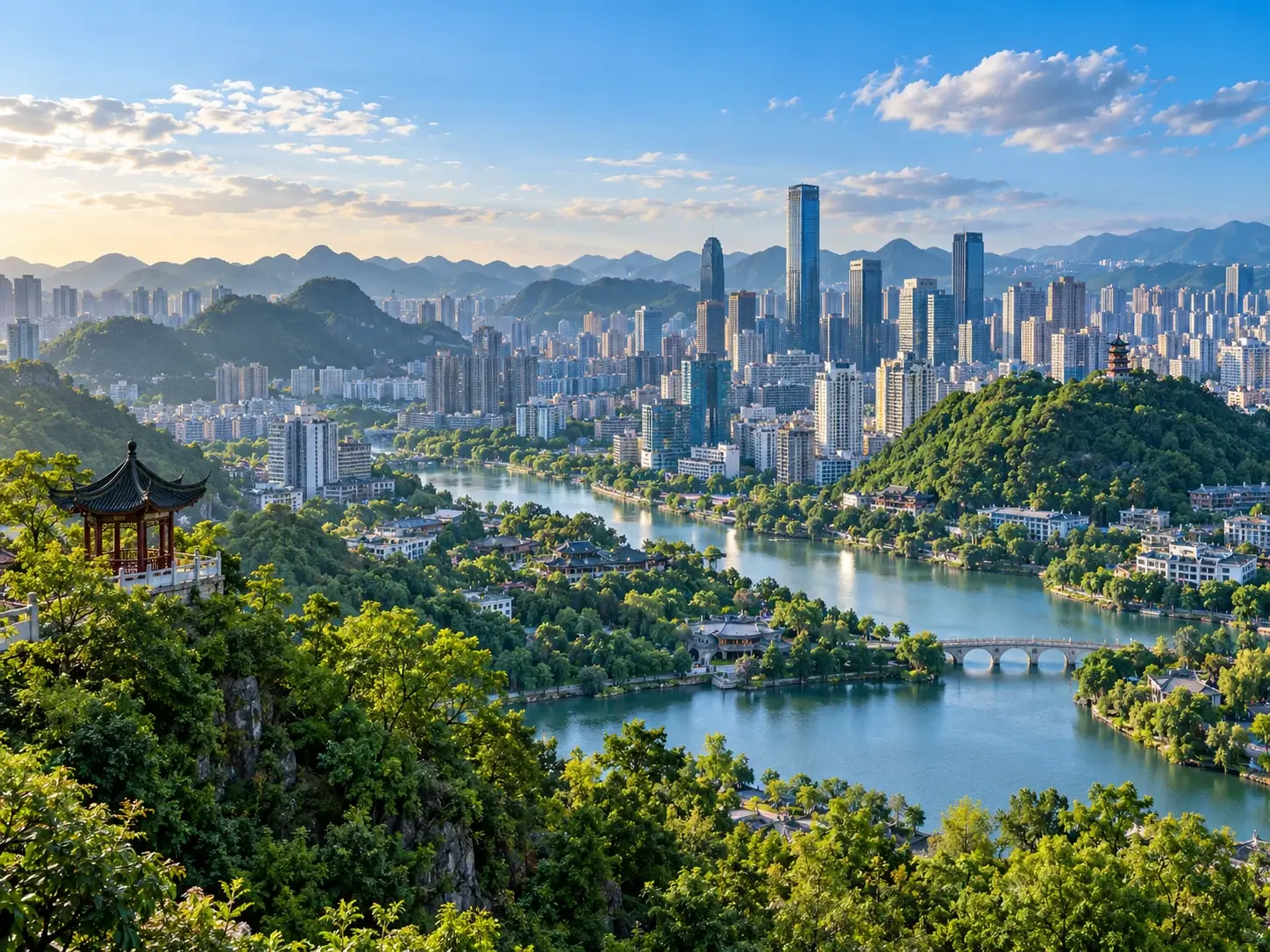 Guiyang skyline wrapped in green karst hills — a river winds through the city, a Chinese pavilion in the foreground and modern towers under a clear blue sky
