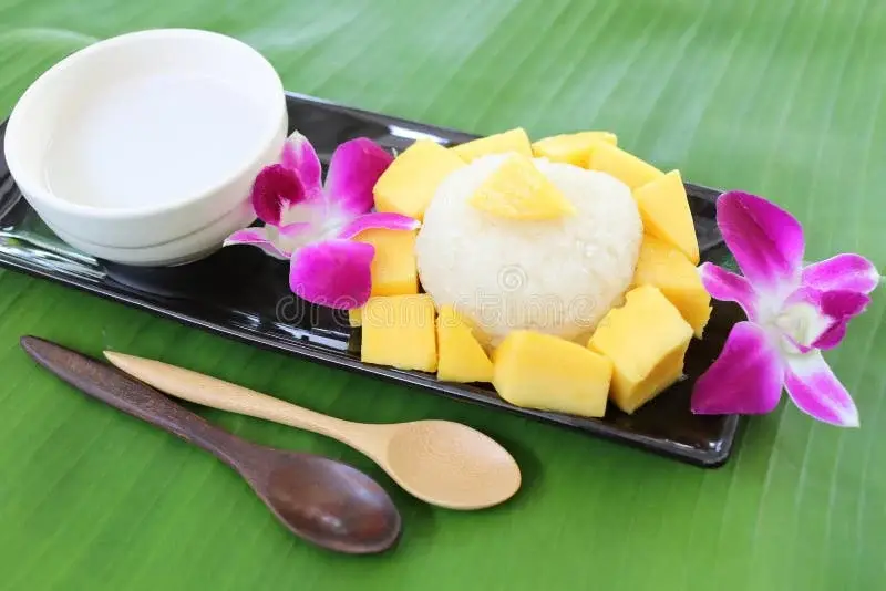 Mango sticky rice with coconut cream on a banana leaf