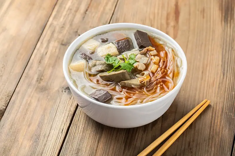 A bowl of Nanjing duck-blood vermicelli soup with duck offal and coriander