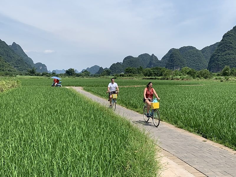 A couple cycling between rice fields near Yangshuo