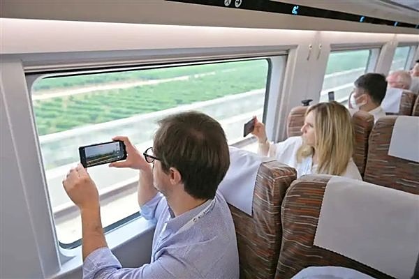 A traveler filming from a high-speed train
