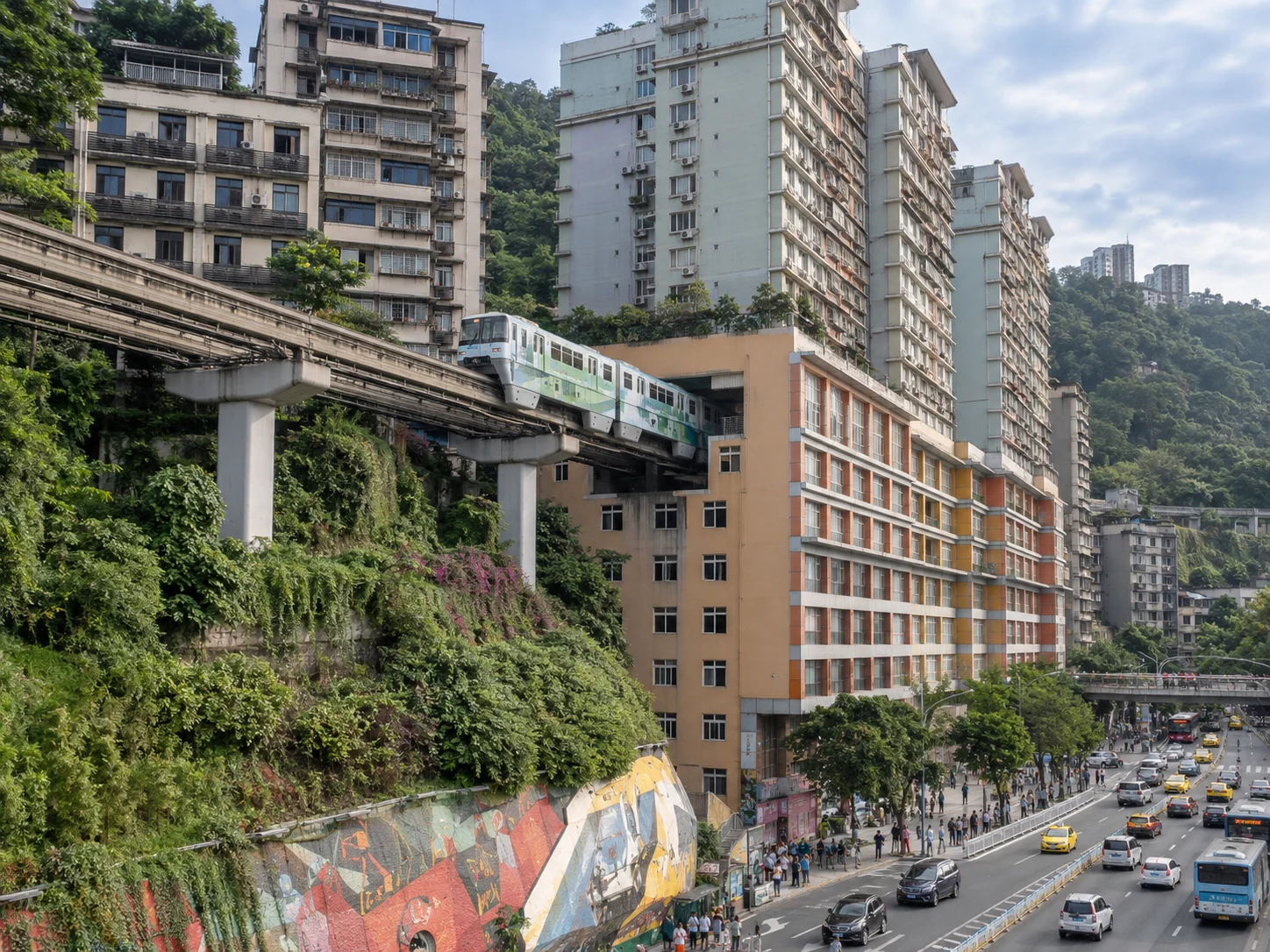 A monorail train gliding past hillside buildings under a clear sky
