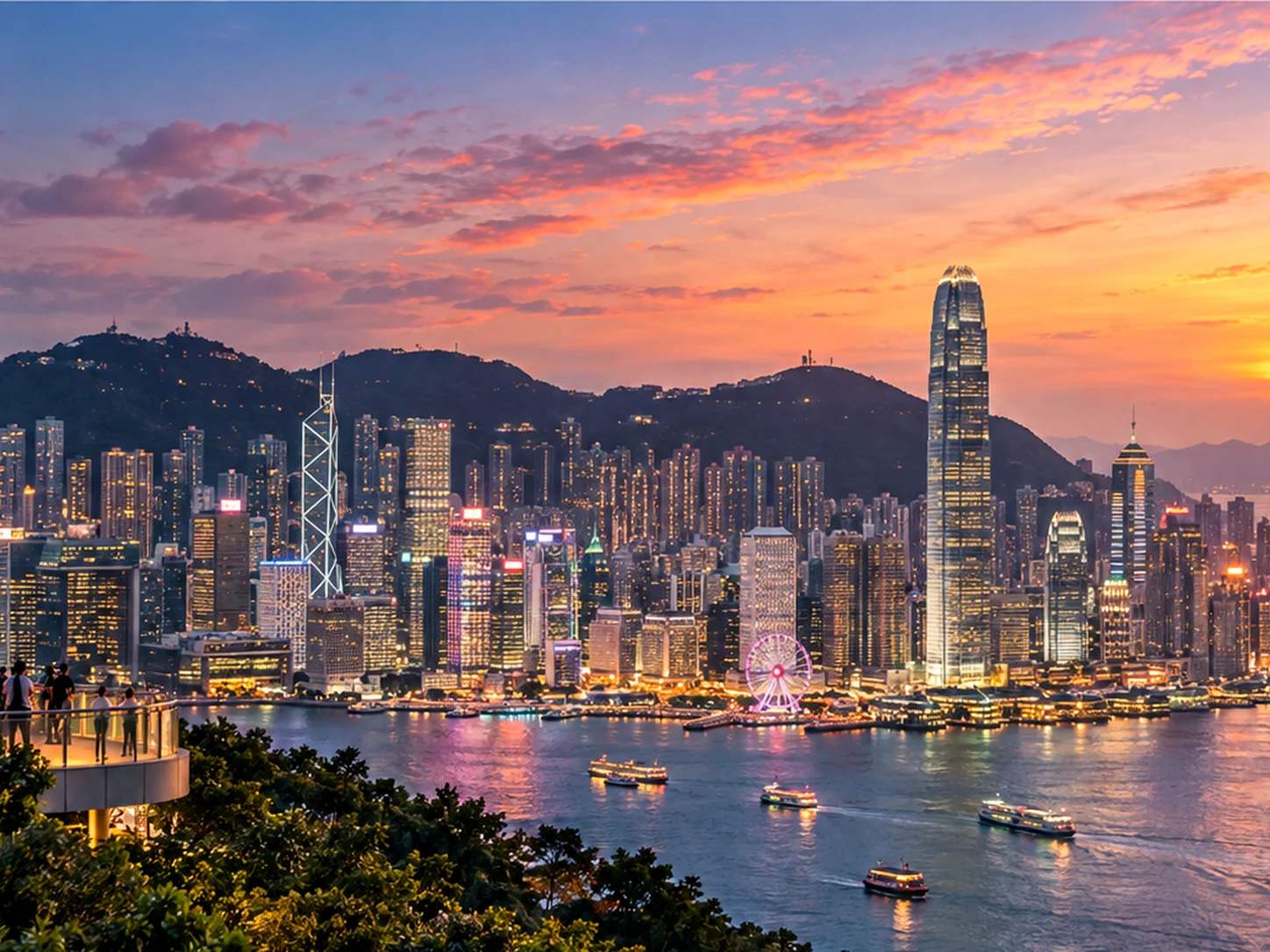 The Hong Kong skyline against mountains and sea at dusk, seen across Victoria Harbour