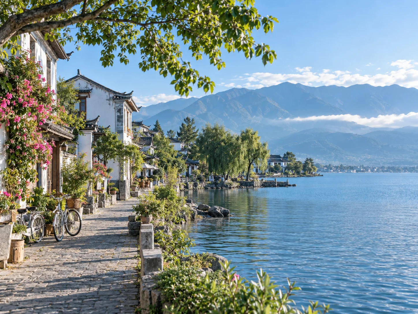 White-walled houses with flowering bougainvillea beside the calm water of Erhai Lake under Cangshan mountain