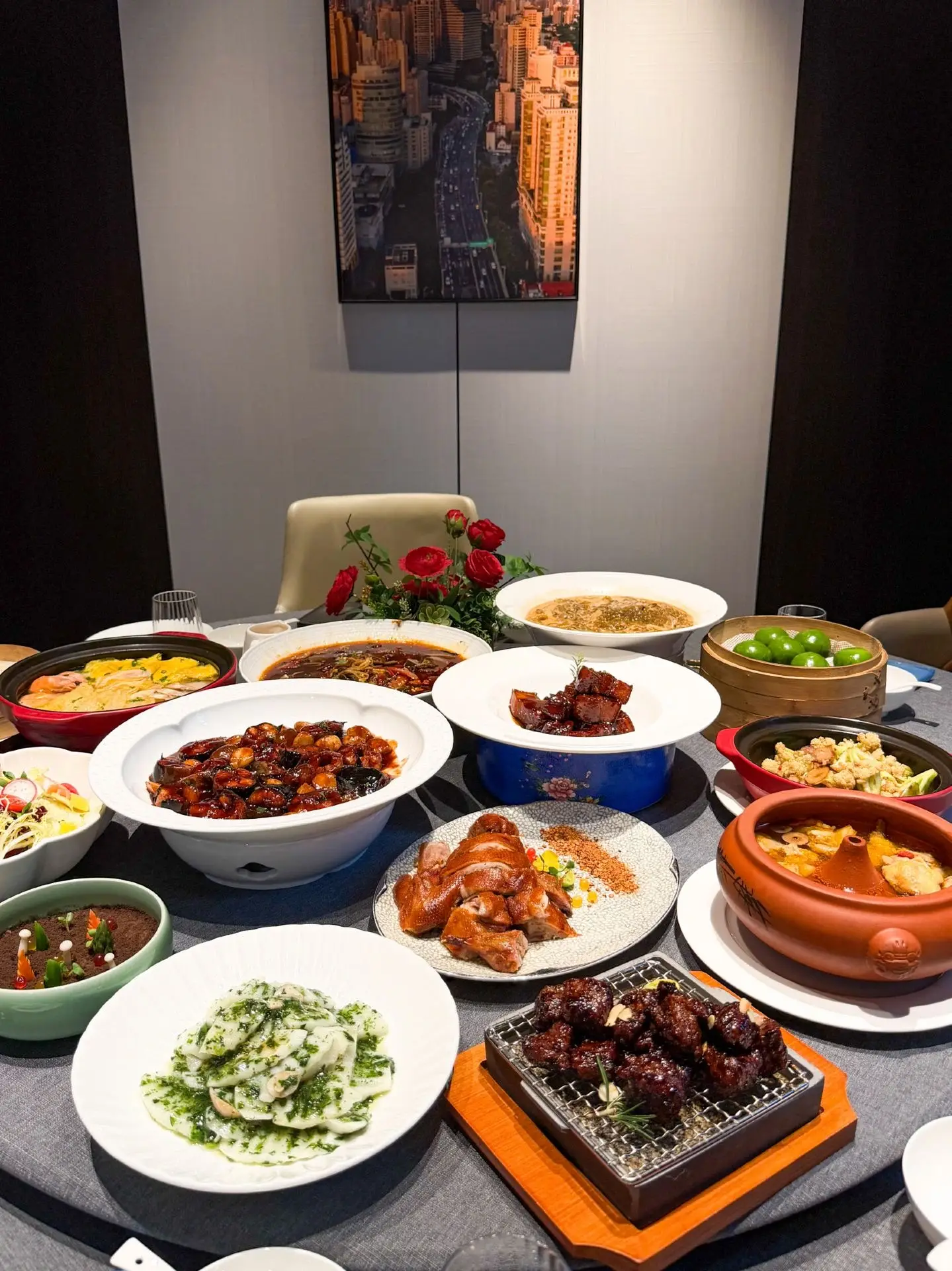 A shared Shanghai restaurant feast with chicken, seafood, vegetables and clay-pot dishes on a charcoal tablecloth