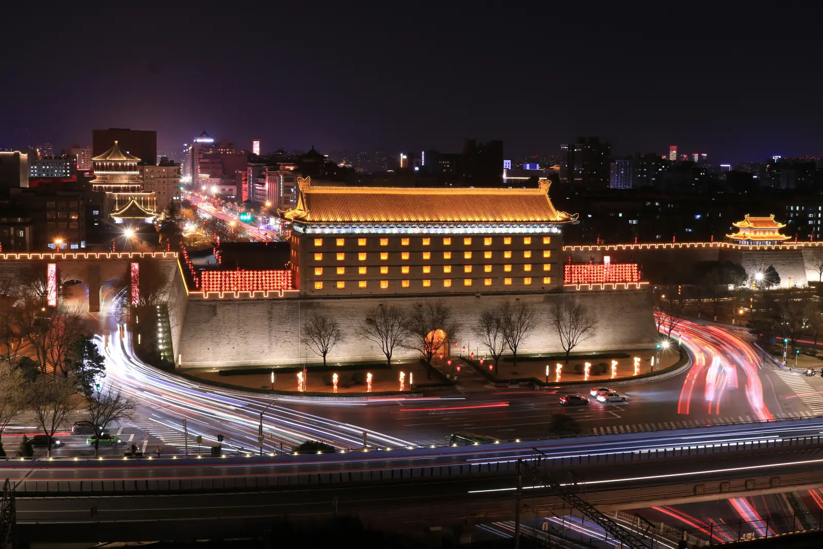Xi’an city gate illuminated at night with traffic light trails