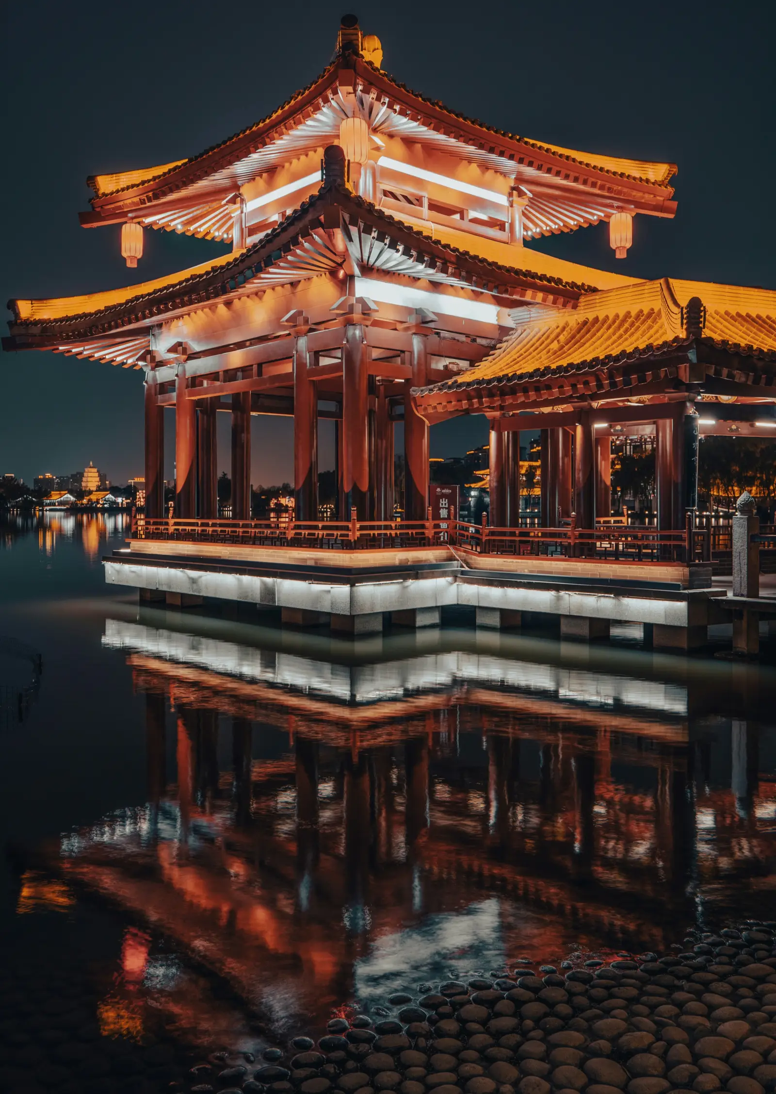 Illuminated palace architecture reflected in water in Xi’an